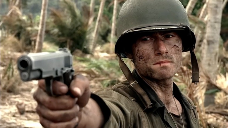 A dirtied PFC Robert Leckie (James Badge Dale) aims a pistol in The Pacific