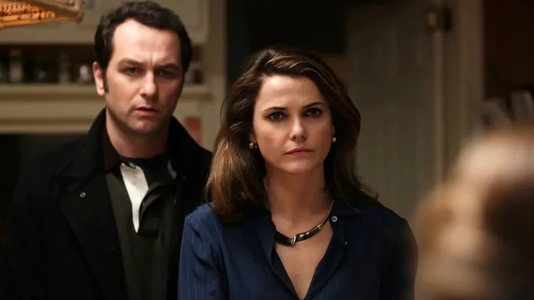 Matthew Rhys and Phillip standing next to Keri Russell as Elizabeth looking at someone (not pictures) incredulously