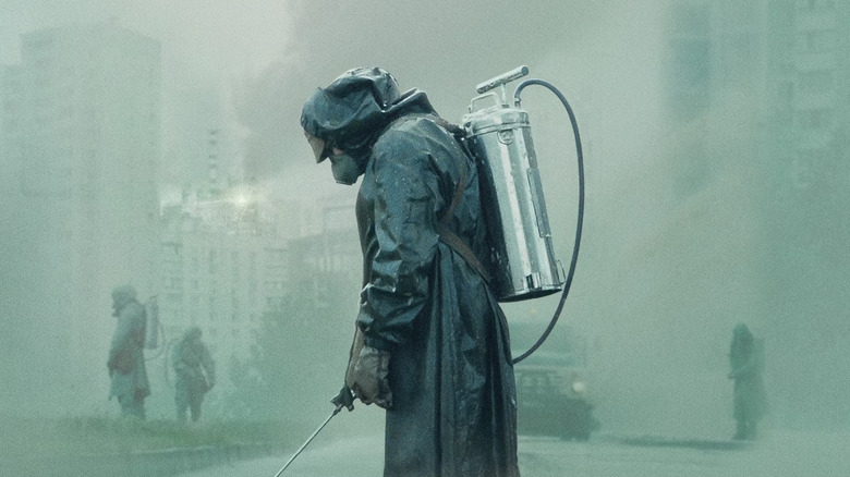 A man in a hazmat suit in a foggy city in Chernobyl