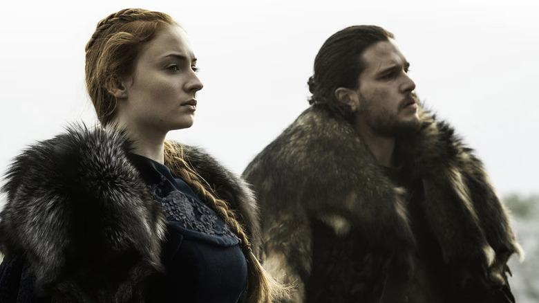 Sophie Turner and Kit Harington as Sansa Stark and Jon Snow on horses in Game of Thrones