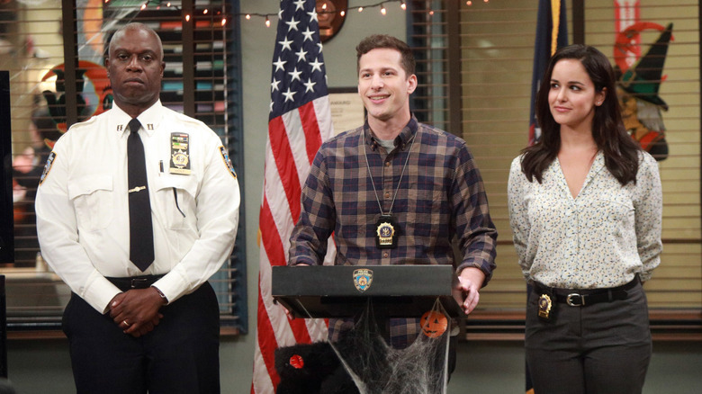 Andre Braugher, Andy Samberg, and Melissa Fumero as Holt, Jake, and Amy giving a speech in Brooklyn Nine-Nine