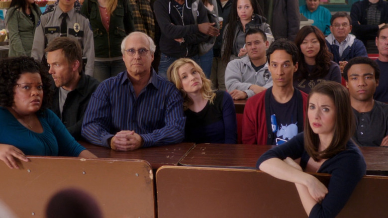 Yvette Nicole Brown, Joel McHale, Chevy Chase, Gillian Jacobs, Danny Pudi, Alison Brie, and Donald Glover as Shirley, Jeff, Pierce, Britta, Abed, Annie, and Troy sitting together in Community