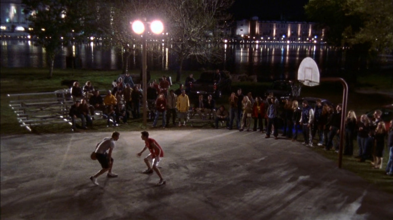 Lucas (Chad Michael Murray) and Nathan (James Lafferty) playing one on one basketball in front of crowd in One Tree Hill