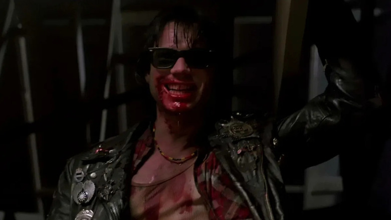 Severen (Bill Paxton) smiling with a bloody grin while wearing sunglasses and a blood-stained shirt in Near Dark (1987).