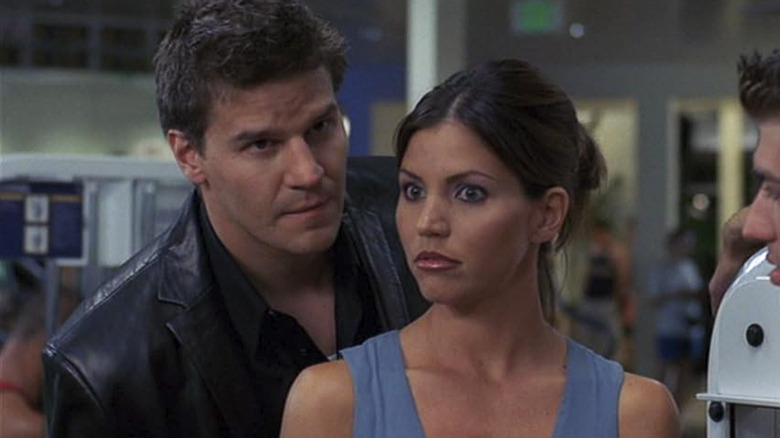 David Boreanaz as Angel standing next to Charisma Carpenter in Angel
