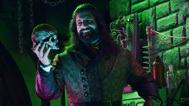 Kayvan Novak as Nandor the Relentless holding a skull in What We Do in the Shadows