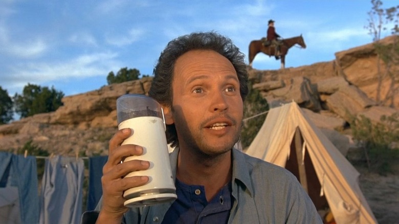 Mitch Robbins (Billy Crystal) holds up a thermos in the campsite in City Slickers