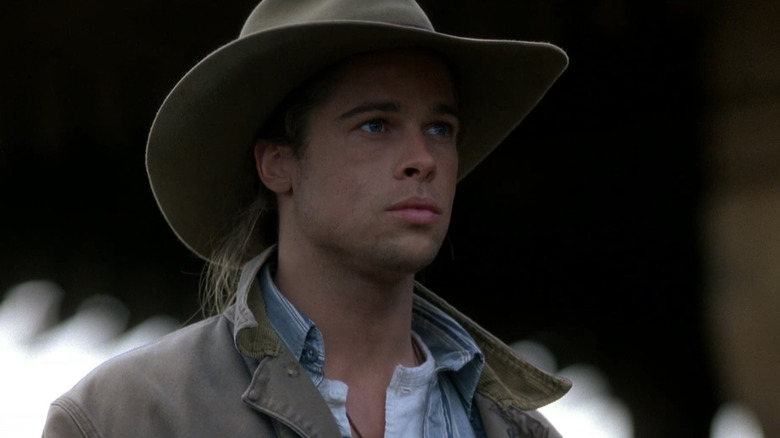 Tristan Ludlow (Brad Pitt) stands moodily outside wearing a cowboy hat in Legends of the Fall