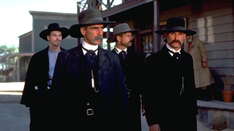 Wyatt Earp (Kurt Russell), Doc Holliday (Val Kilmer), Virgil Earp (Sam Elliott), and Morgan Earp (Bill Paxton) walk through town in Tombstone