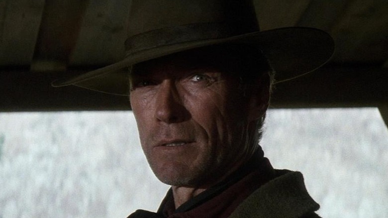 William Munny (Clint Eastwood) stands glaring in a doorway in Unforgiven