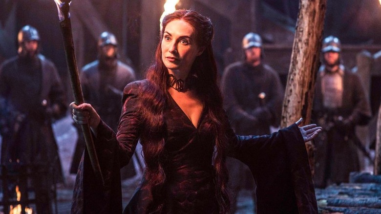 Carice van Houten as Melisandre lighting a pyre in Game of Thrones