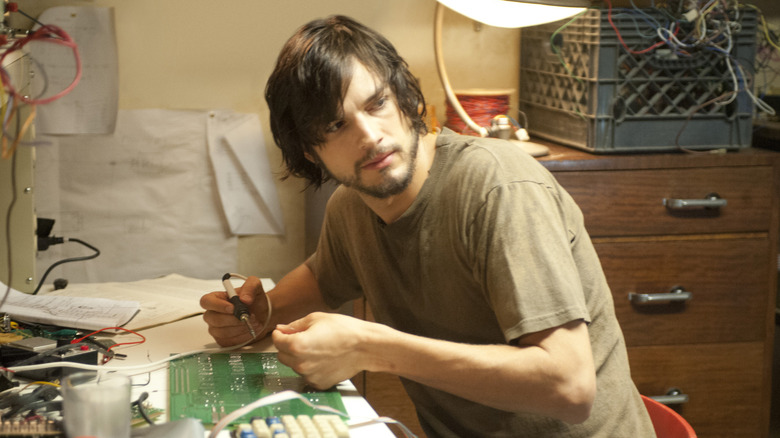Ashton Kutcher as Steve Jobs works on a circuit board in Jobs