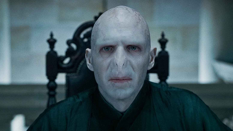 Ralph Fiennes as Voldemort sits in a chair in Harry Potter and the Half-Blood Prince