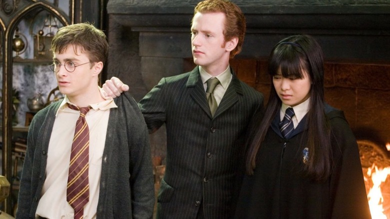 Daniel Radcliffe as Harry Potter and Katie Leung as Cho Chang are held by Chris Rankin as Percy Weasley in Harry Potter and the Order of the Phoenix