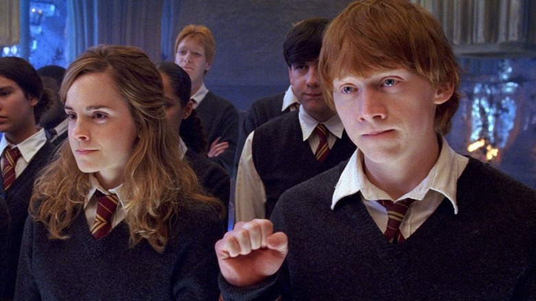 Emma Watson as Hermione and Rupert Grint as Ron Weasley stand among Dumbledore's Army in Harry Potter and the Order of the Phoenix