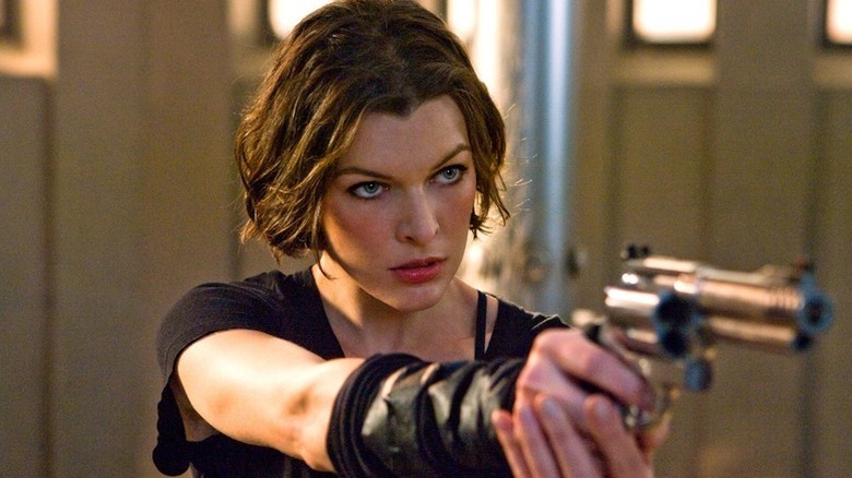 Alice (Milla Jovovich) holding a gun in Resident Evil
