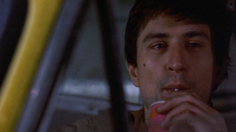 Robert De Niro as Travis Bickle drinking soda in his car in Taxi Driver