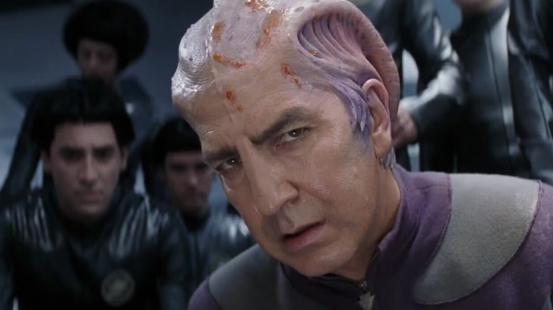 Alexander Dane as Dr. Lazarus (Alan Rickman) kneeling within a crowd of Thermians in Galaxy Quest (1999).
