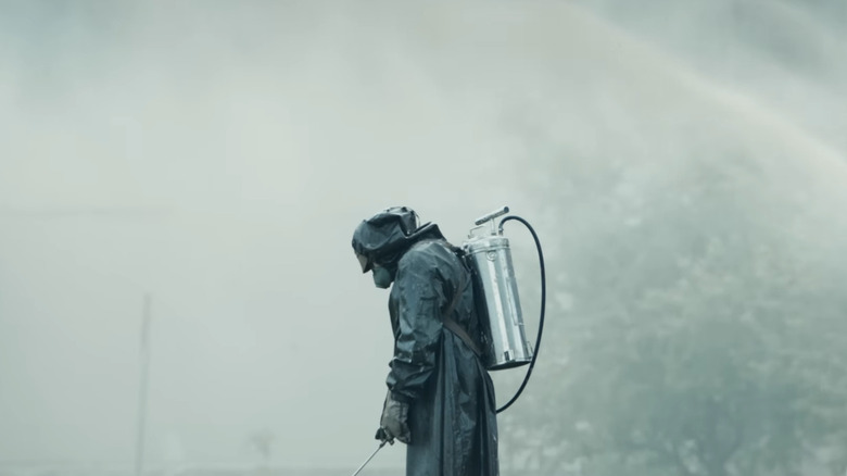 Worker in proto-hazmat suit spraying ground in Chernobyl