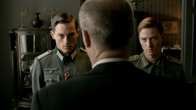 Wilhelm (Volker Bruch) and Friedhelm (Tom Schilling) look at father in Generation War