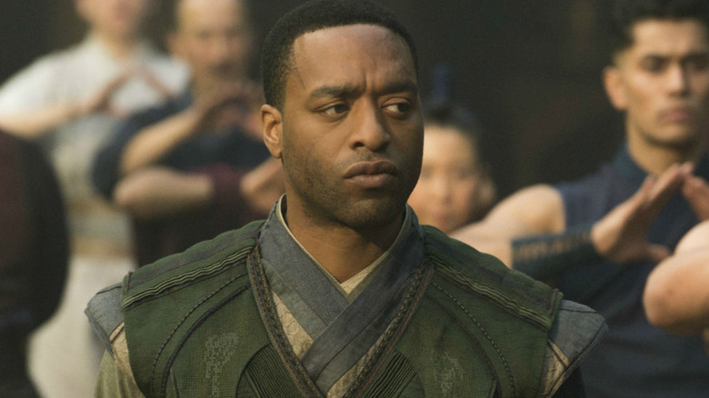 Baron Mordo (Chiwetel Ejiofor) stands among posing students in Doctor Strange (2016)