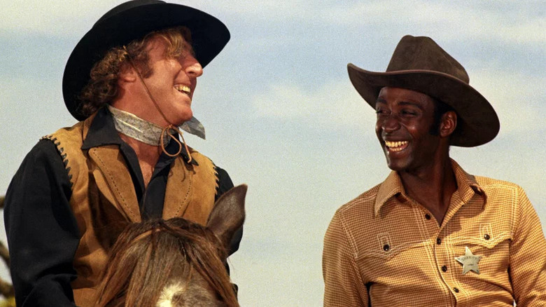 Jim the Waco Kid (Gene Wilder) and Bart (Cleavon Little) share a laugh while riding horses in Blazing Saddles