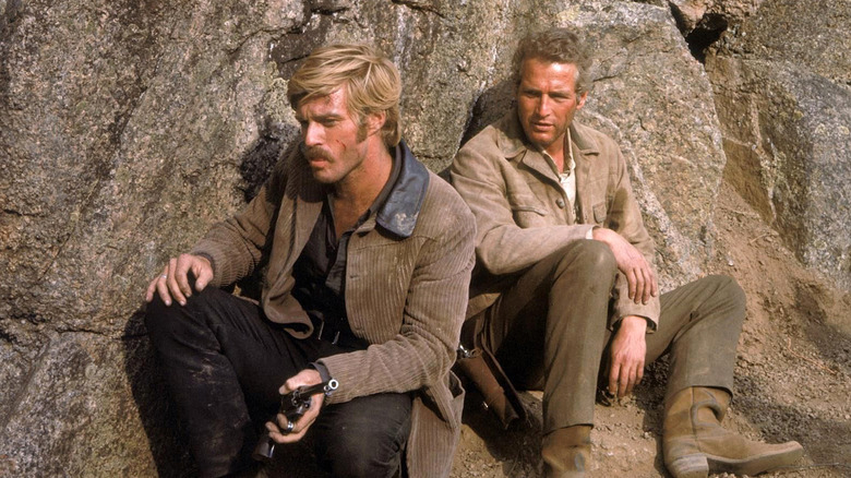 The Sundance Kid (Robert Redford) and Butch Cassidy (Paul Newman) hide against rocks in Butch Cassidy and the Sundance Kid