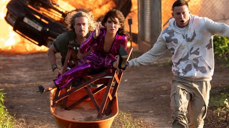 Brad Pitt as Jack, Sandra Bullock as Loretta, and Channing Tatum as Alan escaping from danger in The Lost City