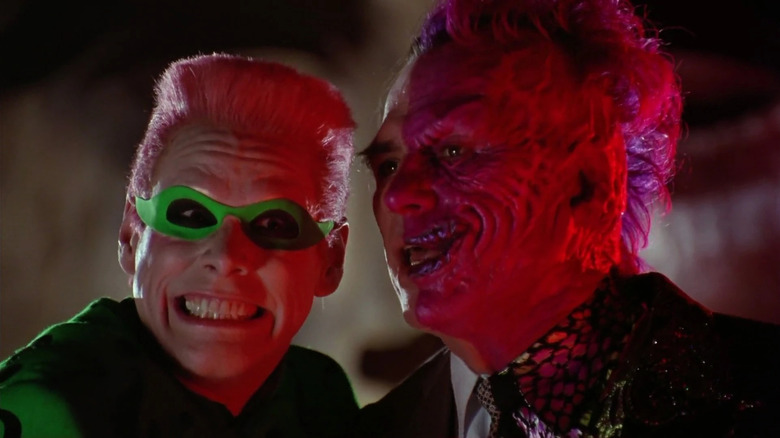 The Riddler (Jim Carrey) and Two-Face (Tommy Lee Jones) smile together in Batman Forever (1995).