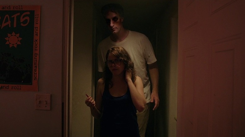 The creature behind Yara (Olivia Luccardi) in It Follows