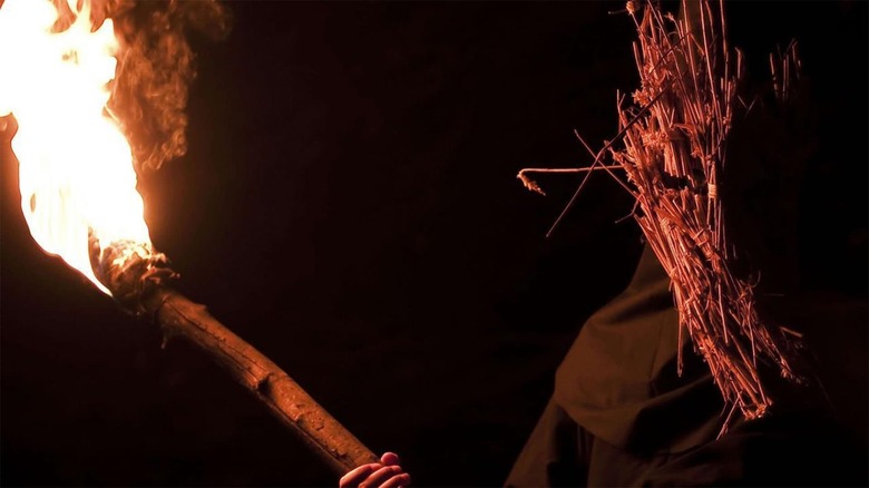 Cult member flaming torch