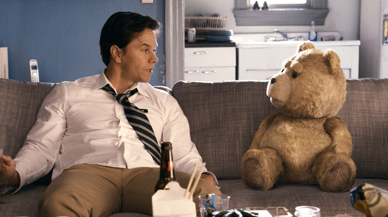 John (Mark Wahlberg) sits with Ted on a couch