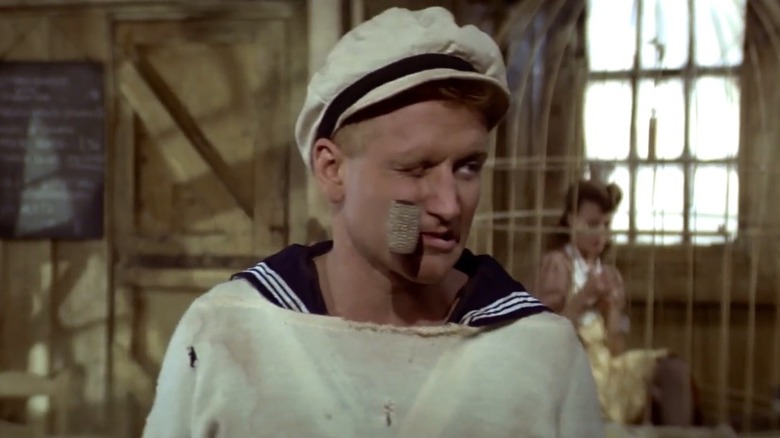 Robin Williams as Popeye with a pipe in his mouth in Popeye