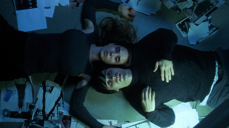 Jared Leto as Harry Goldfarb and Jennifer Connelly as Marion Silver lie among papers in Requiem for a Dream.