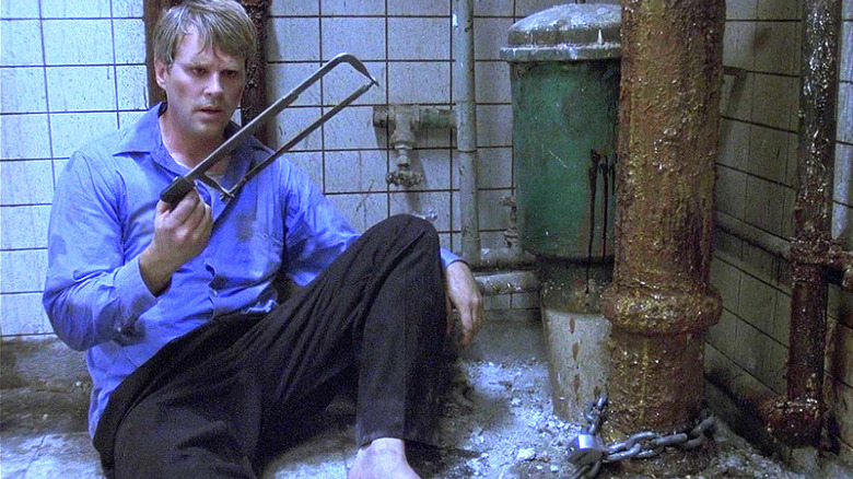 Cary Elwes as Dr. Lawrence Gordon looks at a hacksaw in Saw.