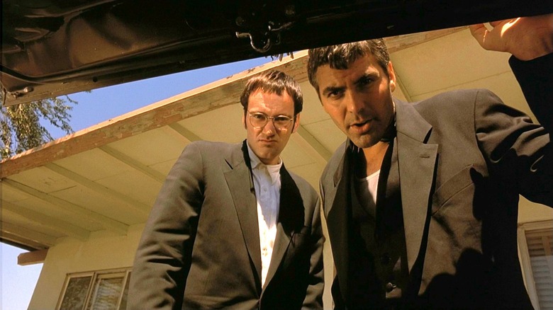 George Clooney as Seth Gecko and Quentin Tarantino as Richard "Richie" Gecko, looking into the trunk of a car from the perspective of the trunk.