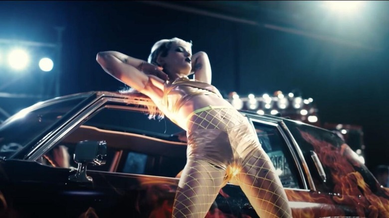 Alexia (Agatha Rousselle) models with a car she's in love with in Titane