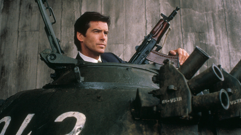 James Bond (Pierce Brosnan) holds an assault rifle sitting in a tank in GoldenEye