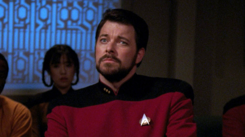 William Riker (Jonathan Frakes) sits warily with Starfleet officers in Star Trek: The Next Generation