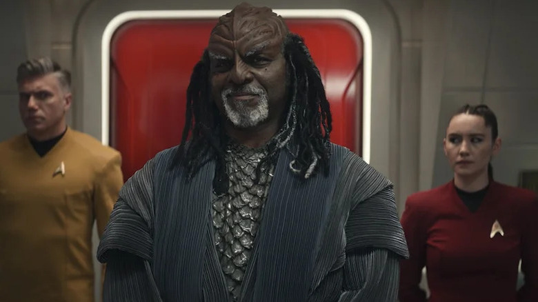 Christopher Pike (Anson Mount) and La'An Noonien Singh (Christina Chong) stand cautiously behind Dak'Rah (Robert Wisdom) in Star Trek: Strange New Worlds