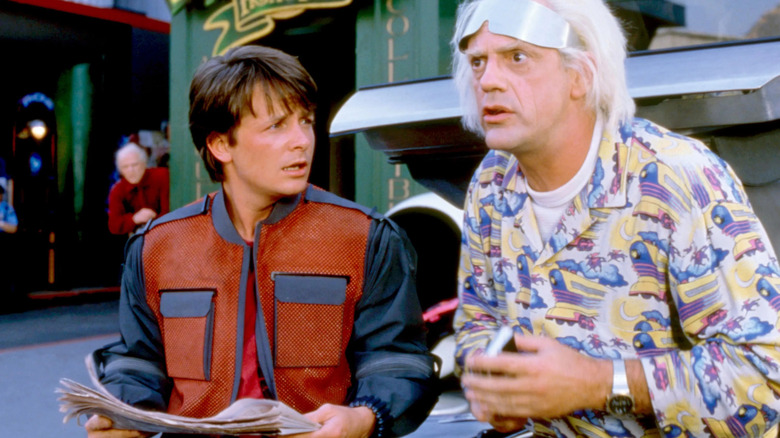 Michael J. Fox as Marty McFly stands next to Christopher Lloyd as Doc Brown in Back to the Future Part II