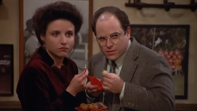 George (Jason Alexander) and Elaine (Julia Louis-Dreyfus) talking and eating in Seinfeld