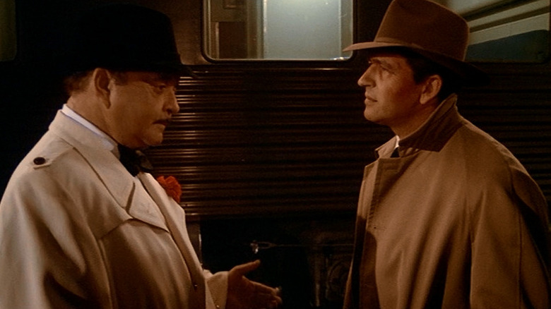 Fargo Gondorff (Jackie Gleason) and Jake Hooker (Mac Davis) speak in a train while wearing trench coats in The Sting II
