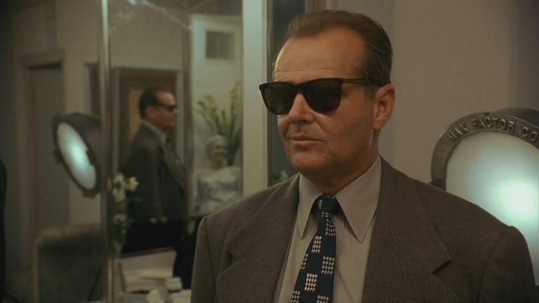 Jake Gittes (Jack Nicholson) smirks wearing sunglasses next to a mirror in The Two Jakes