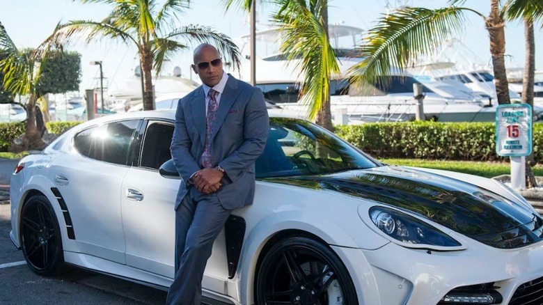 Dwayne Johnson next to a nice car in Ballers