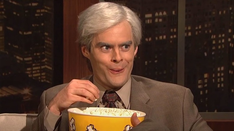Bill Hader as Keith Morrison smiling and eating popcorn on SNL