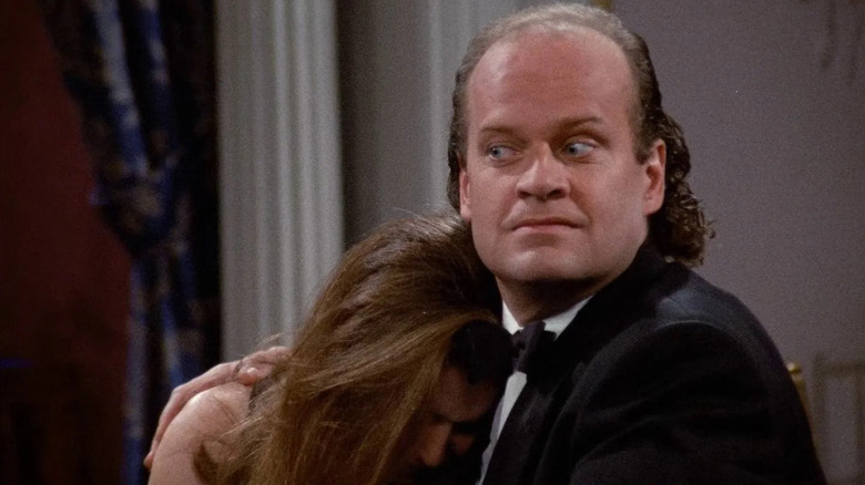 Kelsey Grammer as Frasier Crane holds a crying woman in Frasier.