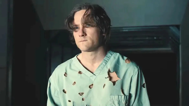 Lewis Pullman as Bob wearing a hospital gown with bullet holes in Thunderbolts*