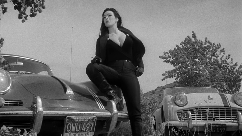 Varla leaning in front of car