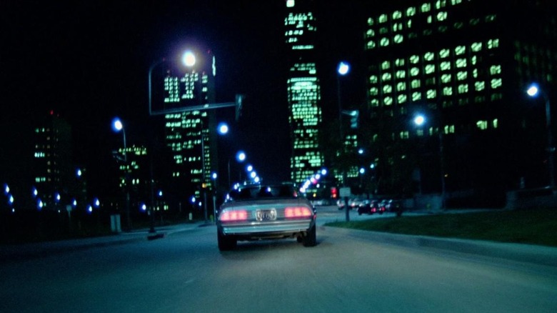 Car driving down streets at night